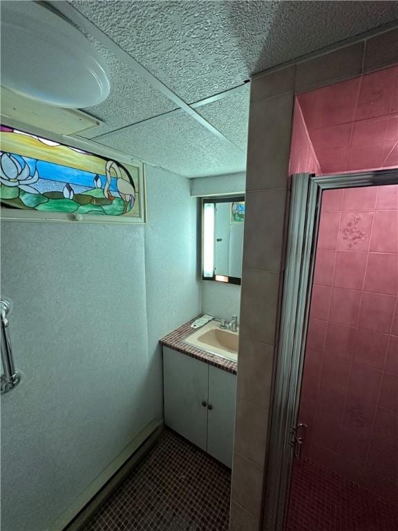 bathroom featuring tile patterned floors, a stall shower, and vanity