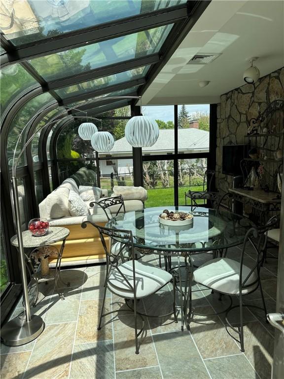 sunroom / solarium with a fireplace and outdoor dining area