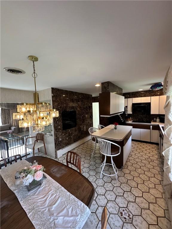 dining area featuring a fireplace and a chandelier