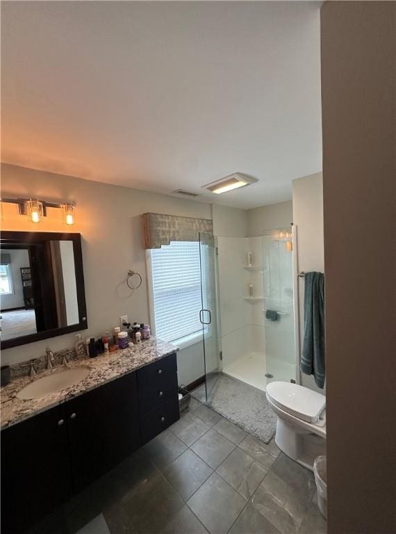 full bath featuring a stall shower, vanity, toilet, and tile patterned flooring