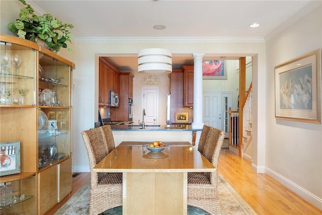 43 Waters Edge, Tiverton, RI 02878 - dining space featuring decorative columns, light wood finished floors, baseboards, crown molding, and stairway