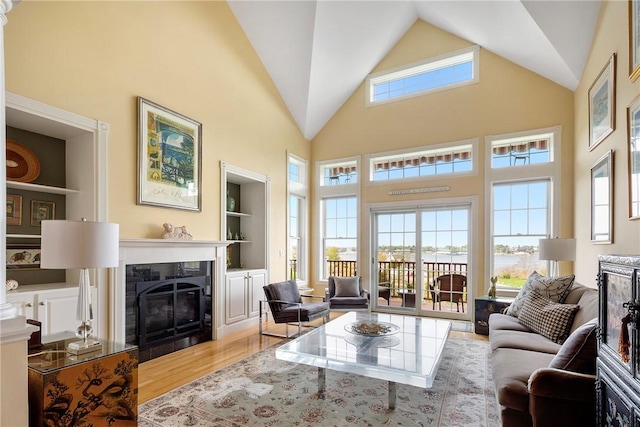 43 Waters Edge, Tiverton, RI 02878 - living room featuring a fireplace, wood finished floors, built in shelves, and high vaulted ceiling