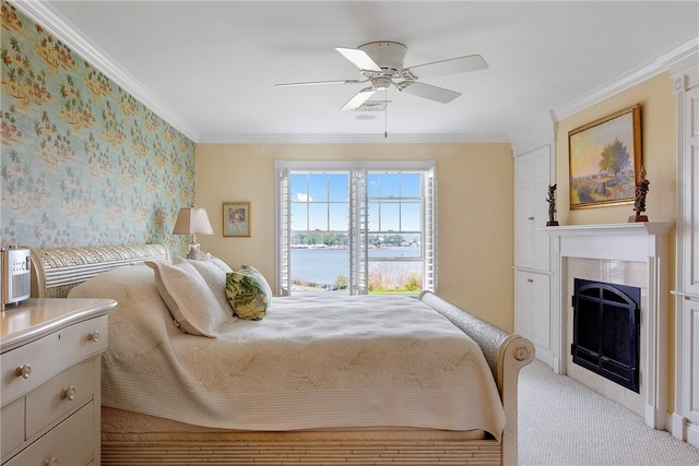 43 Waters Edge, Tiverton, RI 02878 - carpeted bedroom featuring a tiled fireplace, ornamental molding, a water view, and a ceiling fan