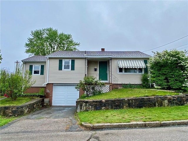 view of front facade featuring a garage, asphalt driveway, a chimney, a front yard, and a shingled roof