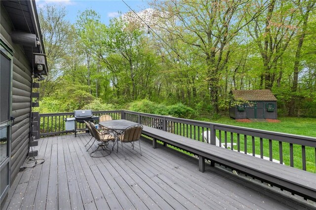 4 Ottawa Trl, Narragansett, RI 02882 - wooden deck featuring outdoor dining area, a storage shed, a lawn, and an outbuilding