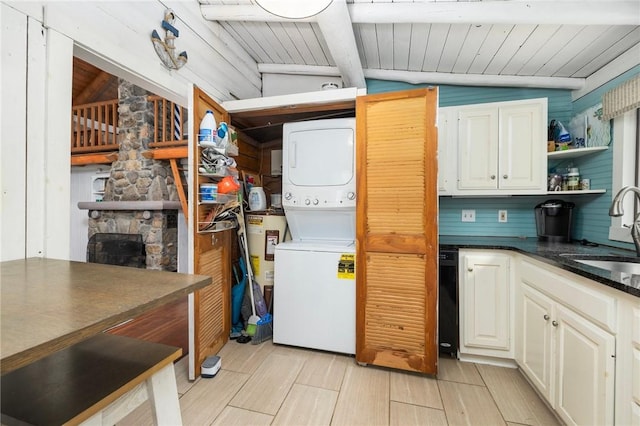 4 Ottawa Trl, Narragansett, RI 02882 - kitchen with stacked washing machine and dryer, a sink, dark countertops, water heater, and open shelves