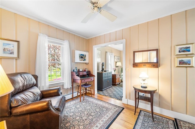 146 Bay View Ave, Bristol, RI 02809 - living area featuring light wood-style floors, a ceiling fan, baseboard heating, and ornamental molding