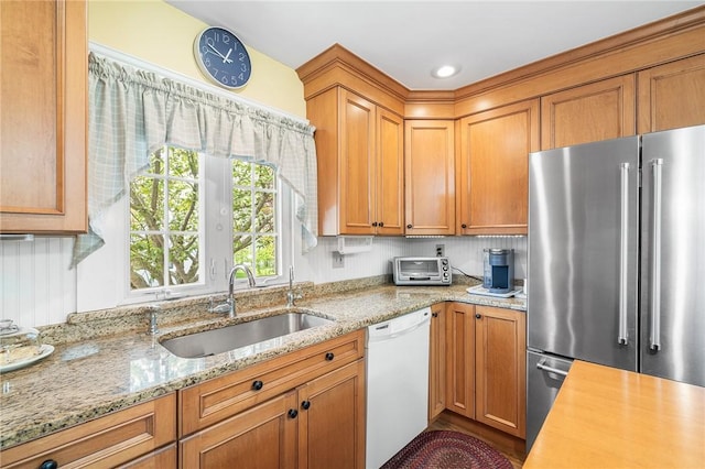 146 Bay View Ave, Bristol, RI 02809 - kitchen featuring high end refrigerator, white dishwasher, a sink, light stone counters, and brown cabinetry
