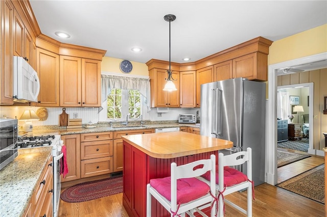 146 Bay View Ave, Bristol, RI 02809 - kitchen with white appliances, a sink, wood finished floors, a center island, and pendant lighting