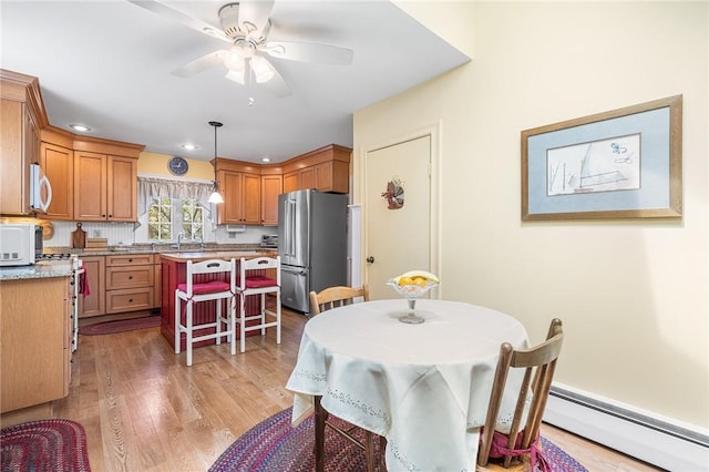 146 Bay View Ave, Bristol, RI 02809 - dining room with baseboard heating, light wood-style flooring, ceiling fan, and recessed lighting