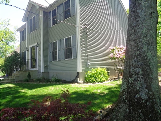 view of side of home with a yard