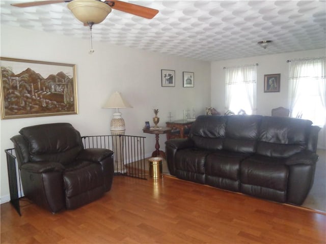 living room featuring a ceiling fan and wood finished floors