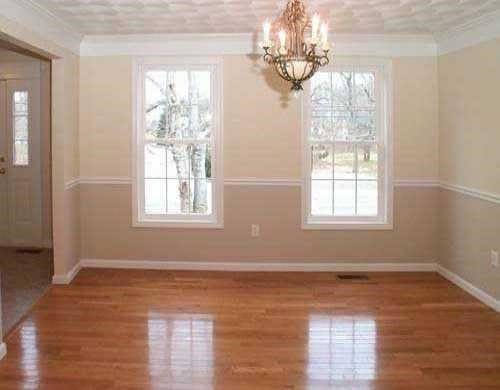 unfurnished dining area with a chandelier, plenty of natural light, ornamental molding, baseboards, and wood finished floors