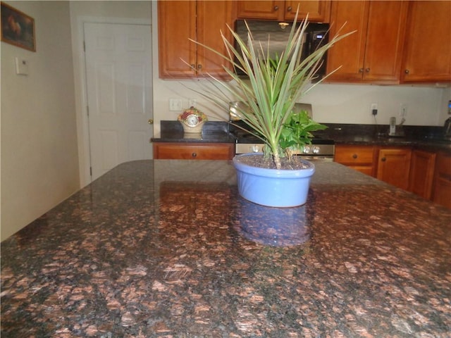 kitchen with brown cabinets and dark stone counters