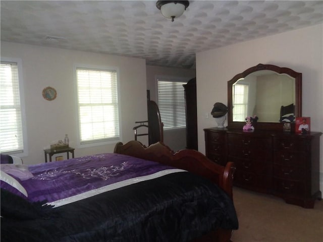 bedroom featuring multiple windows and light colored carpet