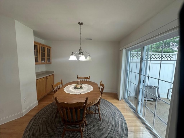 19 Calabria Ct Unit 19, Westerly, RI 02891 - dining room featuring a chandelier, baseboards, and light wood finished floors