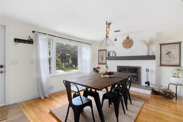 37 Charles St, Barrington, RI 02806 - dining area featuring a brick fireplace, light wood-style floors, baseboards, and track lighting