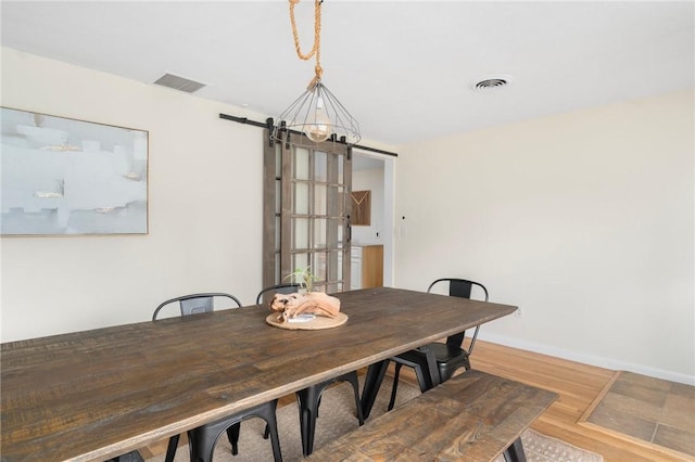37 Charles St, Barrington, RI 02806 - dining room featuring wood finished floors, a chandelier, a barn door, and baseboards