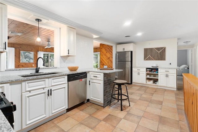 37 Charles St, Barrington, RI 02806 - kitchen with stainless steel appliances, a sink, white cabinets, and wooden walls
