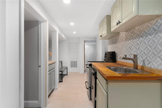 37 Charles St, Barrington, RI 02806 - kitchen with electric stove, butcher block counters, recessed lighting, a sink, and light wood finished floors