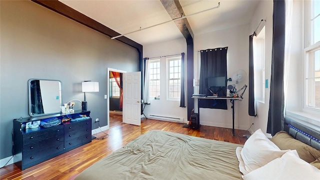 bedroom with baseboard heating, wood finished floors, beamed ceiling, and baseboards
