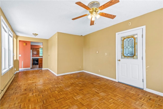 unfurnished living room featuring a baseboard heating unit, baseboards, and a ceiling fan