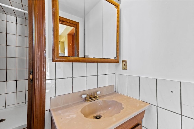 bathroom featuring tile walls, vanity, tiled shower, and decorative backsplash