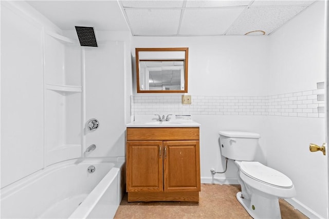 full bathroom featuring toilet,  shower combination, a drop ceiling, and vanity