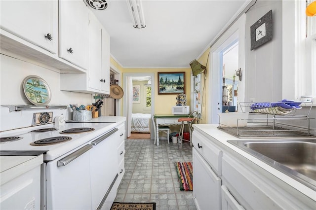 kitchen with white appliances, light floors, light countertops, white cabinets, and crown molding