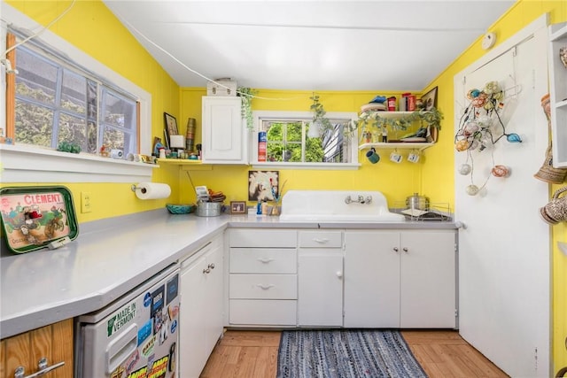 kitchen featuring a sink, white cabinetry, and light countertops