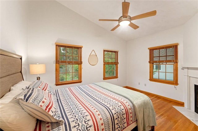 6 Windward Cir, Narragansett, RI 02882 - bedroom with light wood finished floors, lofted ceiling, a fireplace with flush hearth, a ceiling fan, and baseboards