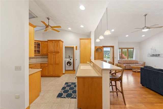 6 Windward Cir, Narragansett, RI 02882 - kitchen with washer / dryer, a ceiling fan, a sink, a kitchen breakfast bar, and open floor plan