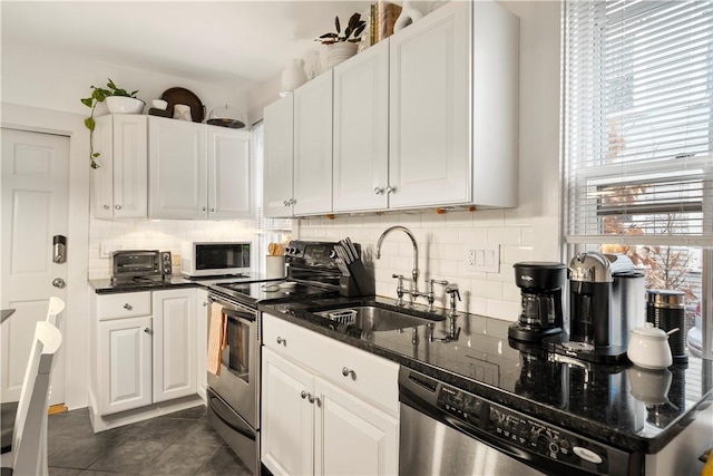33 Marsh St Unit 1, Newport, RI 02840 - kitchen featuring appliances with stainless steel finishes, a sink, decorative backsplash, white cabinets, and dark stone countertops