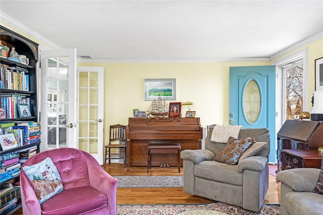 living area with ornamental molding, french doors, and wood finished floors