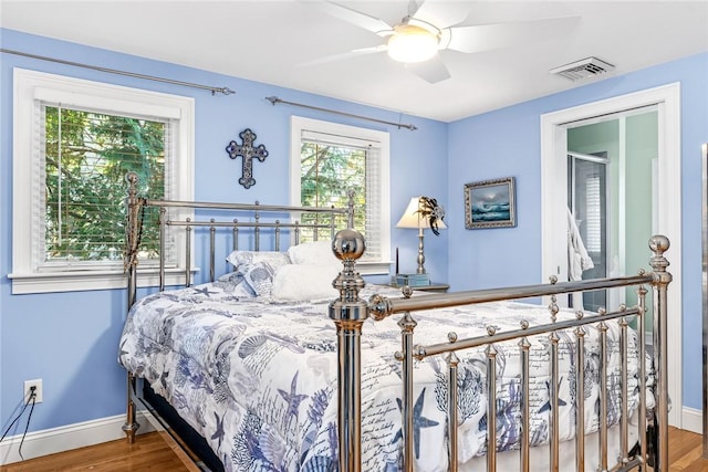 bedroom featuring wood finished floors, baseboards, and ceiling fan