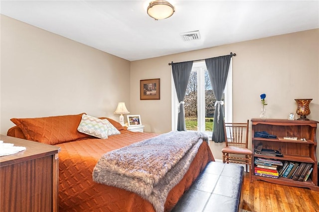 bedroom featuring access to exterior and wood finished floors