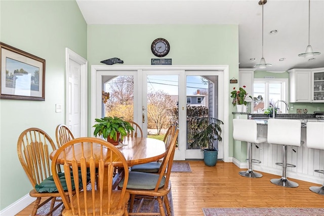 dining room with light wood-type flooring, baseboards, and recessed lighting