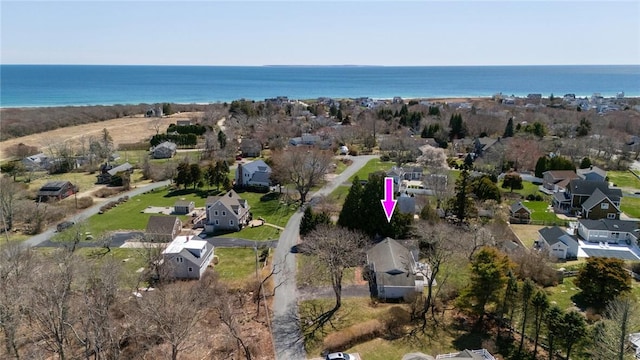 aerial view of property and surrounding area featuring nearby suburban area and a large body of water