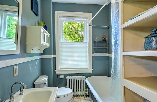 bathroom with radiator, a sink, toilet, and plenty of natural light