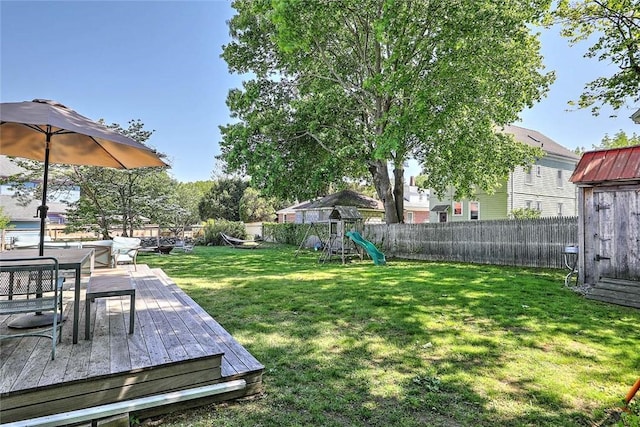 view of yard with a playground, a deck, and outdoor dining area