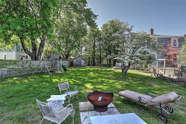view of yard featuring a storage shed, a playground, and an outdoor structure