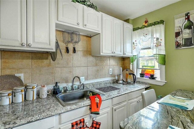 10 Westcott Ave Unit 3, Boston, MA 02124 - kitchen featuring a sink, white cabinets, and backsplash