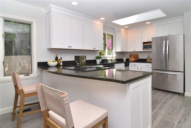 244 Kingstown Rd, Narragansett, RI 02882 - kitchen with appliances with stainless steel finishes, white cabinets, a peninsula, light wood-style floors, and recessed lighting