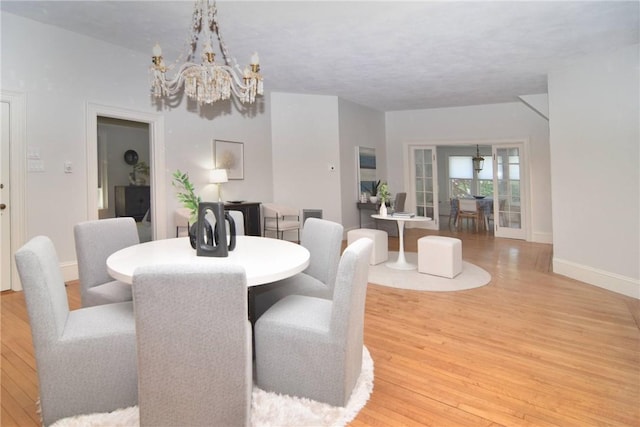 244 Kingstown Rd, Narragansett, RI 02882 - dining space with a chandelier, light wood-style flooring, and baseboards