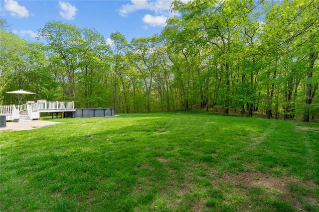 195 Deer Ridge Dr, North Kingstown, RI 02874 - view of grassy yard with a deck, an outdoor pool, and central AC unit