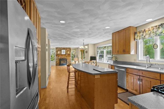 195 Deer Ridge Dr, North Kingstown, RI 02874 - kitchen with appliances with stainless steel finishes, a kitchen bar, a chandelier, a kitchen island, and light wood finished floors