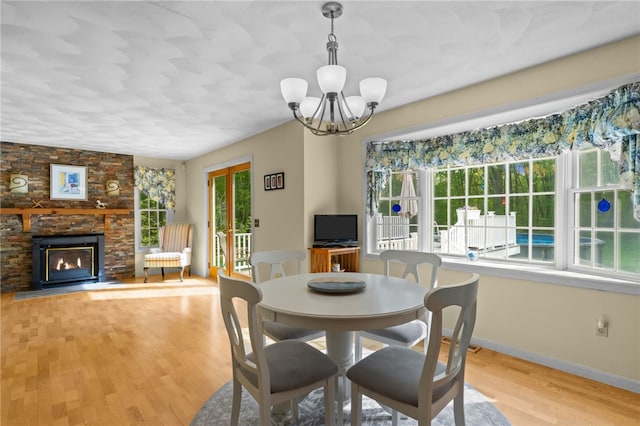 195 Deer Ridge Dr, North Kingstown, RI 02874 - dining area with a chandelier, light wood-type flooring, a fireplace, and baseboards