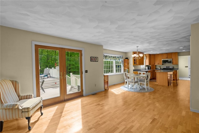 195 Deer Ridge Dr, North Kingstown, RI 02874 - dining area with a chandelier, french doors, light wood-style flooring, and baseboards