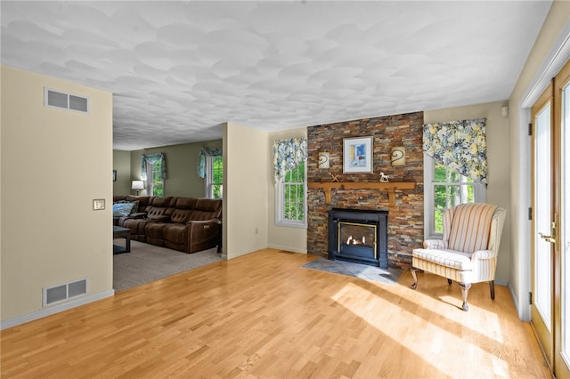 195 Deer Ridge Dr, North Kingstown, RI 02874 - living room featuring healthy amount of natural light, wood finished floors, baseboards, and a stone fireplace