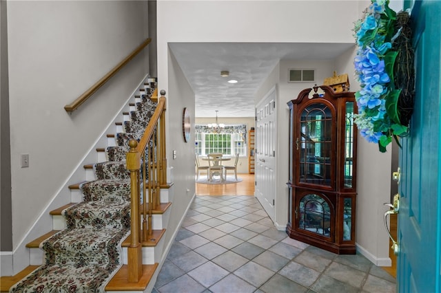 195 Deer Ridge Dr, North Kingstown, RI 02874 - entryway featuring stairway, a chandelier, baseboards, and tile patterned floors